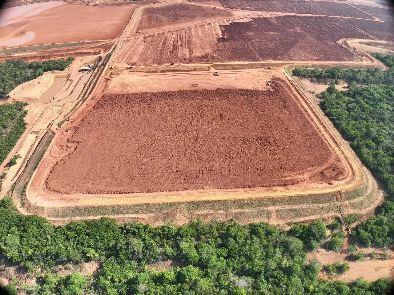 Vista aérea da área da Barragem SP5 em fechamento, com taludes conformados ao redor