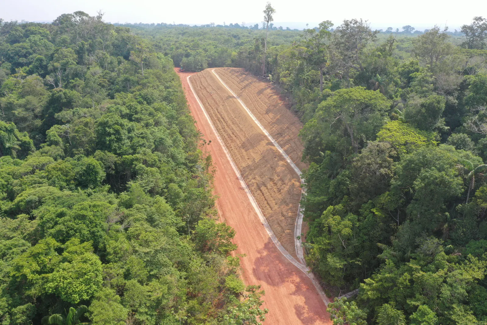 Faixa de talude conformada com canaleta de drenagem, entre a floresta densa